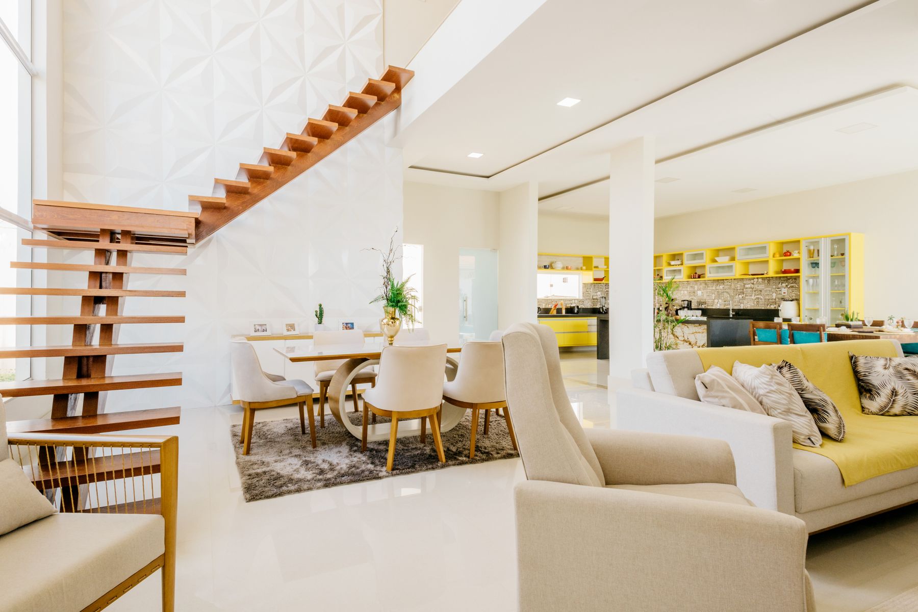 A bright open-plan home with a dining area and a yellow-accented kitchen